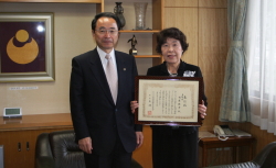 市役所を訪れ、全国大会での表彰を速水市長（左）に報告した西原倍子さん