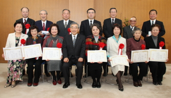 溝口県知事から選定状を受け取った谷戸邦夫さん（後列左から3人目）と仁子さん（前列左から3人目）夫妻ら「しまねナイスパートナー」のみなさん。