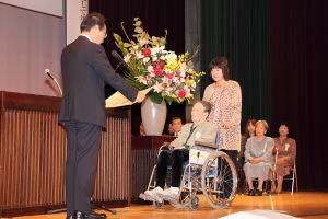 内閣総理大臣祝状を手渡される永井ミツヱさん