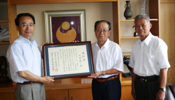 川渕昭一さん（中央）の功労をたたえる田部会長（右）と速水市長