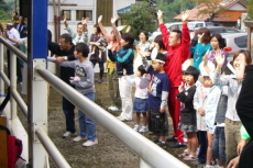 校歌を歌ってトロッコ列車を見送る久野小学校児童ら