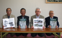 郷土誌を手に、左から原喜弘駅前自治会長、黒田直幸編纂副委員長、吉木彰編纂委員長、細木英明編纂副委員長