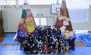 巨人が完成しみんなで記念撮影。作品は八重山の魔人(左)と入間の巨人