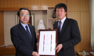 12月24日、市役所で速水市長に受賞を報告した別木重夫さん(右)