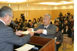 加茂交流センター雇用協議会の舟木清会長から辞令書を受け取る同センター長の田中久隆さん