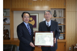 3月25日、周藤利夫さん（右）が市役所を訪れ、速水市長に第45回さくら祭り中央大会で、さくら功労者表彰を受けたことを報告