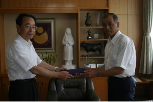 8月27日、入間コミュニティー協議会の岡田治喜会長(右)が「入間郷土誌」の発刊を速水市長に報告。