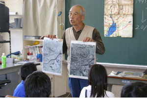 末永浩さんは原爆投下前と後の長崎市の写真を見比べながら子どもたちに核兵器の恐ろしさを訴えました。