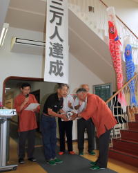 海潮温泉「桂荘」運営委員会の宮川昇会長から田部信夫さんに記念品が手渡されました