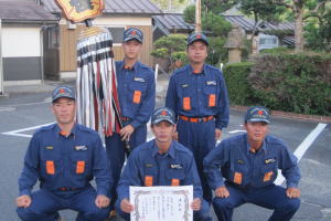 小型ポンプの部で3位に入賞した木次方面隊の選手のみなさん(前列左から 指揮者 上野城(こうのしろ)保(やす)明(あき)さん、1番員 藤原(ふじはら)隆(たか)文(ふみ)さん、2番員 周藤(すとう)公平(こうへい)さん、後列左から 3番員 安部(あべ)淳一(じゅんいち)さん、吸管補助員 田部(たなべ)信(のぶ)雄(お)さん)
