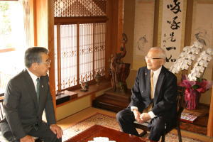 溝口県知事と歓談される飯塚さん(右)