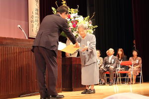 内閣総理大臣祝状を手渡される松崎(まつざき)光野(みつの)さん