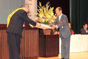 上代会長から感謝状を受け取る岡田(おかだ)隆(たか)宣(のぶ)さん