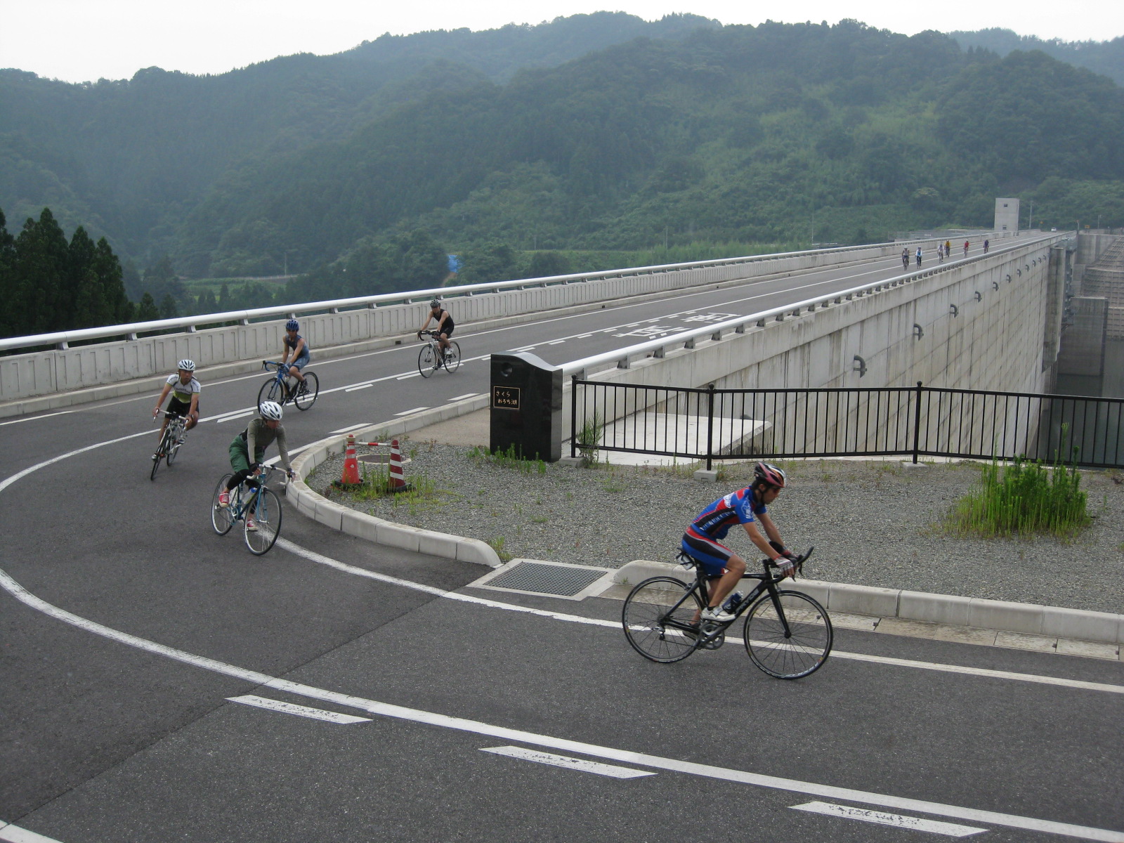 ダム湖堤体上をバイクで走る写真