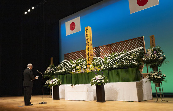 追悼のことばを述べる難波会長